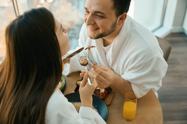 若いカップルで愛でロマンチックな朝食で居心地の良い環境で 男で快適なバスローブ — ストック写真