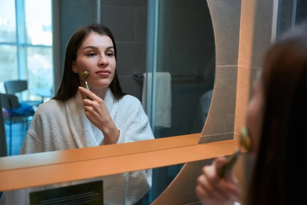 Csinos Fiatal Áll Tükör Előtt Fürdőszobában Arcmasszázst Magának Egy Jáde — Stock Fotó