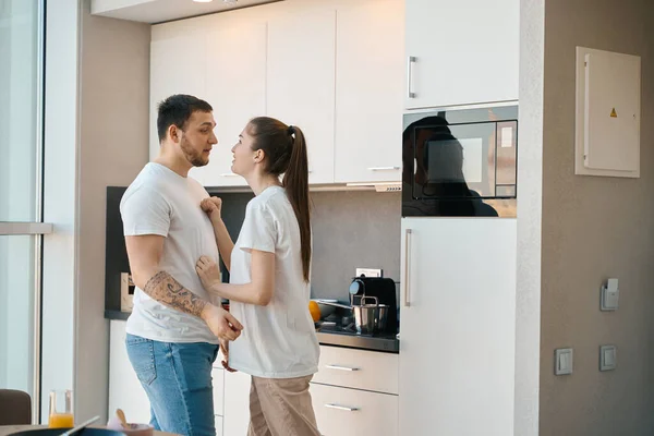 年轻夫妇在厨房里把事情搞得井井有条 穿家居服的男人把事情搞得一团糟 — 图库照片