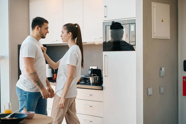 年轻的丈夫和妻子在厨房里进行感情交流 男人手臂上有纹身 — 图库照片