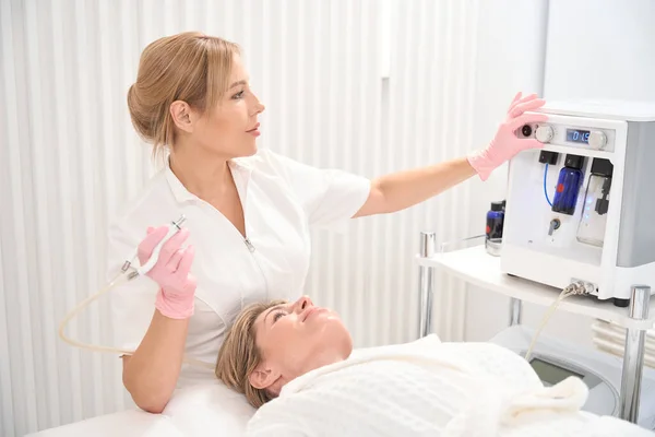 Jovem Cosmetologista Ajusta Laser Co2 Para Procedimento Resurfacing Pele Paciente — Fotografia de Stock