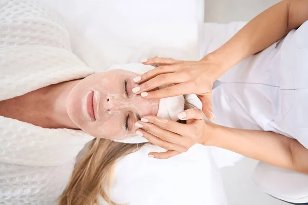 Specjalista Kosmetolog Stosuje Maskę Odmładzającą Twarz Kobiety Pacjent Cieszy Się — Zdjęcie stockowe