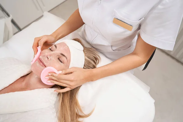Kosmetolog Zdejmuje Maskę Odmładzającą Dla Kobiety Specjalnymi Gąbkami Pacjent Cieszy — Zdjęcie stockowe