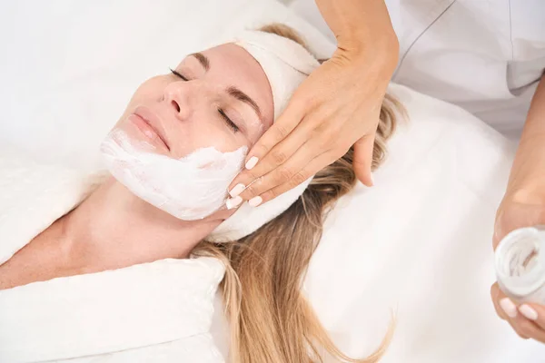 美容医療クリニックでの皮膚注入セッションで女性 美容師は クライアントの顔の皮膚に特別な血清を適用します — ストック写真