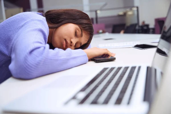 身穿时髦服装的疲惫女工把头靠在手上 睡在开放的办公室里 — 图库照片