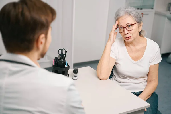 Oudere Dame Klaagt Bij Dokter Hoofdpijn Therapeut Maakt Een Afspraak — Stockfoto