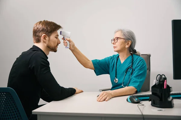 Bearded Patient Female Doctor Measures Temperature Modern Thermometer Male Therapists — Stock Photo, Image