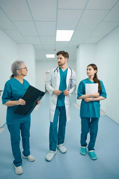Tři Kolegové Doktorů Procházejí Nemocniční Chodbou Doktoři Mají Rukou Složky — Stock fotografie