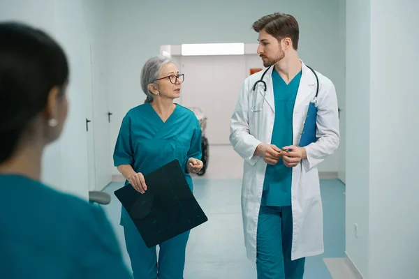 Junger Mann Und Eine Ältere Frau Arztuniform Gehen Den Krankenhausflur — Stockfoto