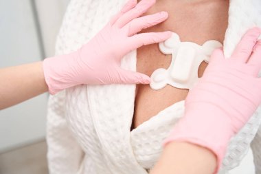 Teşhis koyucu, Holter muayenesi için özel bir sensör takar. Sensör, hastanın kalp bölgesine sabitlenir.