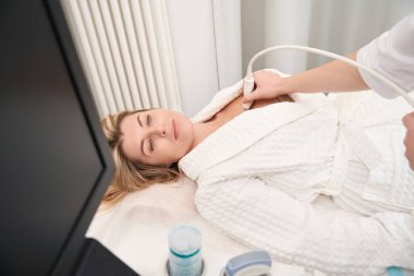 Teşhis departmanının çalışanı bir hastanın kalbinin ultrasonunu yapar. Departmanın modern ekipmanları vardır.