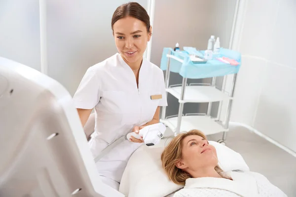 Wykwalifikowany Kosmetolog Przeprowadza Zabiegi Aging Dla Klienta Kliniki Medycyny Estetycznej — Zdjęcie stockowe