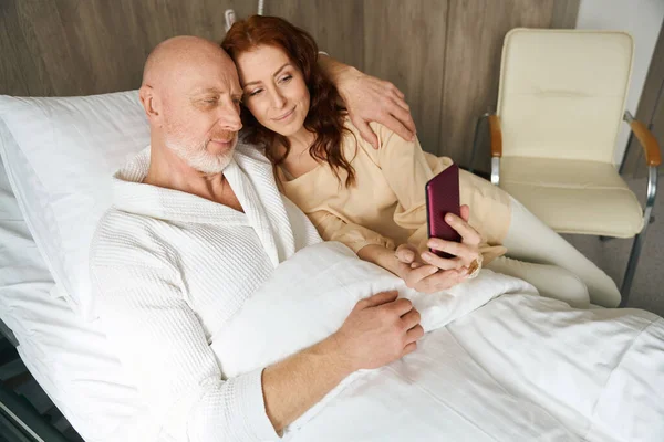 Щасливий Чоловік Жінка Лежать Ліжку Обіймах Перегляд Мобільного Телефону Приміщенні — стокове фото