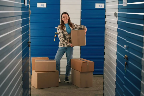 Happy Woman Holding Big Cardboard Box Standing Storage Warehouse Many — Stock fotografie