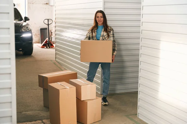 Genç Bayan Büyük Bir Karton Kutu Tutuyor Depoda Bir Sürü — Stok fotoğraf