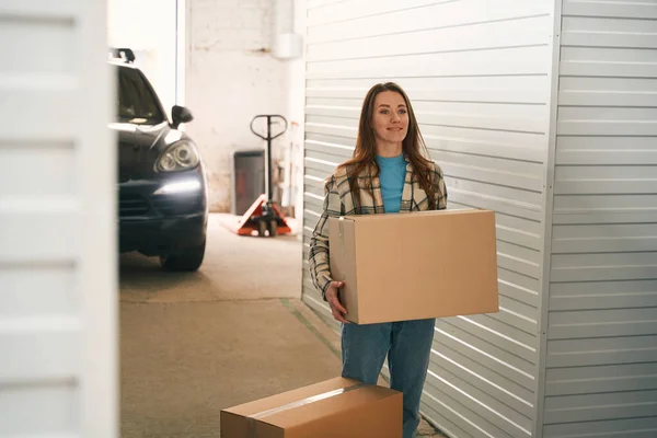 Smiling Woman Holding Big Cardboard Box Standing Storage Warehouse — Stock Photo, Image