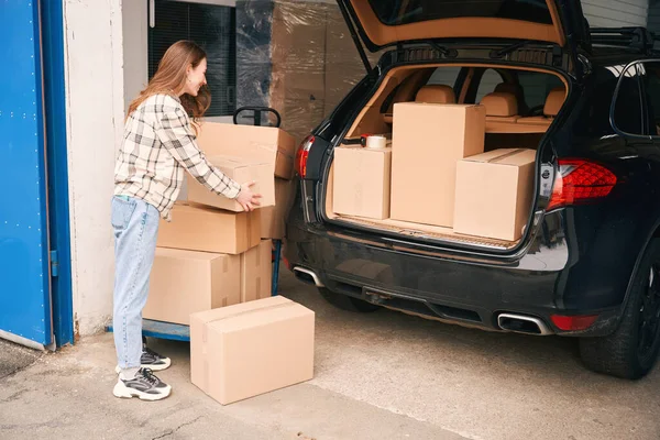 Bayan Depolama Ünitesi Olan Bir Arabanın Bagajına Karton Kutular Koyuyor — Stok fotoğraf
