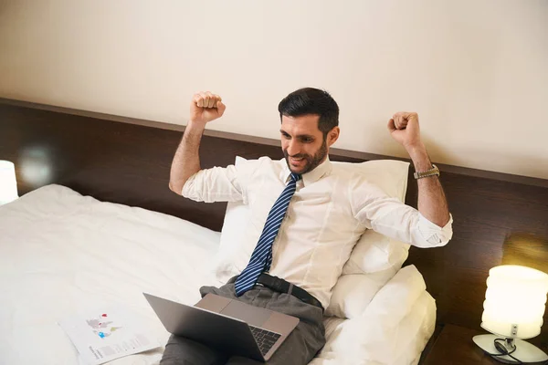 Mężczyzna Bez Rozbierania Się Pracuje Laptopie Wygodnym Łóżku Raduje Się — Zdjęcie stockowe