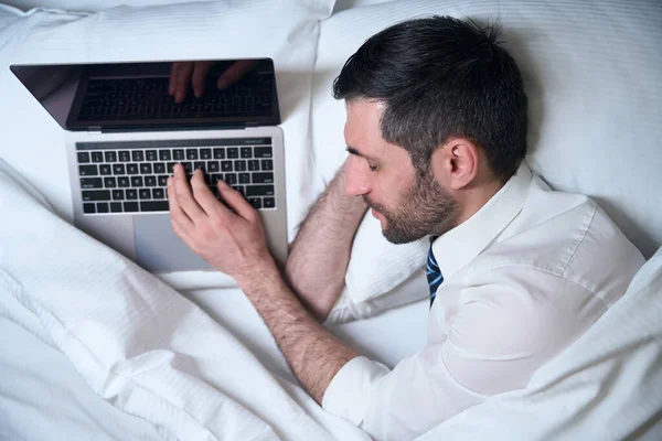 Втомлений Чоловік Заснув Роздягаючись Роботі Ноутбуці Він Оселився Зручному Ліжку — стокове фото