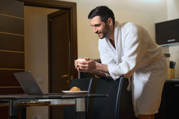 宾馆的客人在厨房和餐厅的笔记本电脑前 有咖啡和糕点 — 图库照片