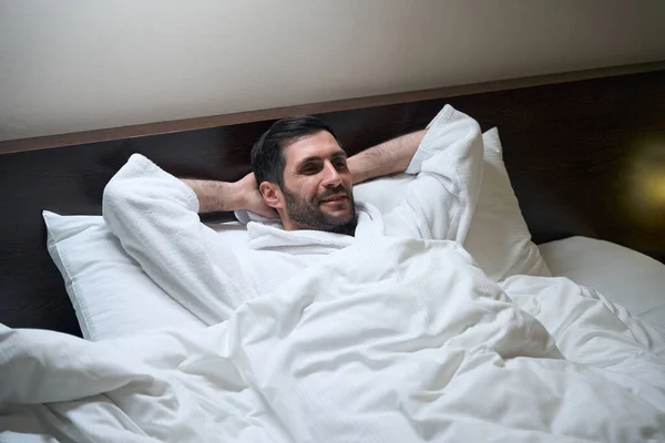 Przystojny Mężczyzna Szlafroku Odpoczywa Łóżku Leży Miękkich Poduszkach — Zdjęcie stockowe