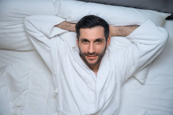 Задоволений Відпочиваючий Чоловік Лежить Ліжку Готельному Номері Він Зручному Халаті — стокове фото