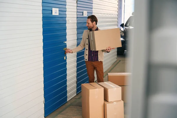 Smiling Guy Opening Storage Room Warehouse Holding Big Cardboard Box — Stock Photo, Image