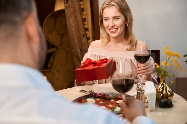레스토랑에서 낭만적 식사를 하면서 사랑하는 여자에게 상자를 제공하는 — 스톡 사진