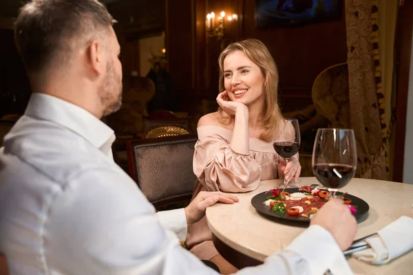 幸せなカップルは赤ワインを飲み 豪華なレストランでロマンチックなディナーを楽しみます — ストック写真