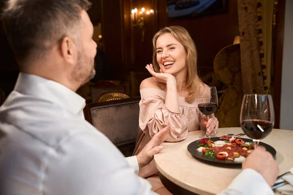 大人の男と彼の魅力的な女性がお互いに話し合い レストランのテーブルで夕食をとる — ストック写真