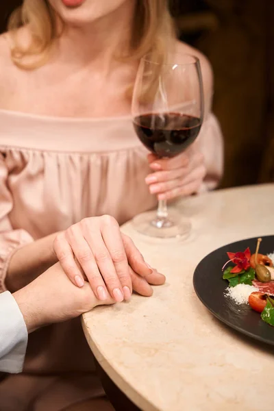 お互いに手を取り合い レストランでテーブルでロマンチックなディナーを楽しむ素敵なカップルの終わり — ストック写真