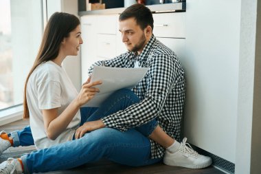 Mutlu gülümseyen eşler oturur, kucaklaşır, mutfakta yerde yatar, basit ev kıyafetleri giyen adamlar...