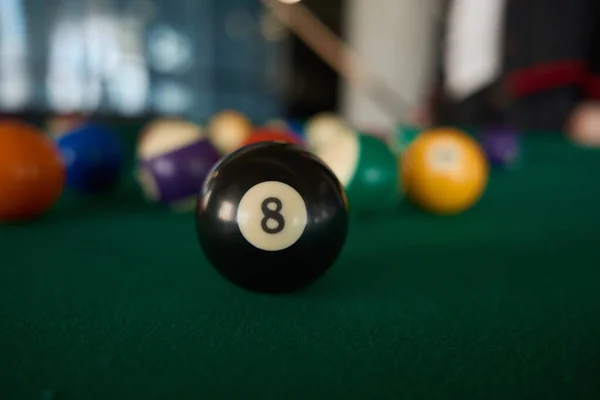 黒のビリヤードボールの上のビューを閉じます8番目のプールテーブルの上にゲームボールのぼやけた背景に — ストック写真