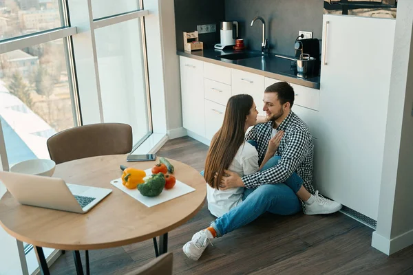 Happy Young Spouses Sit Embracing Floor Kitchen Viewport Indoors — Stock Photo, Image