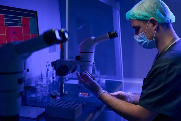 戴防护面罩和手套的科学家实验室工作人员在显微镜下准备脐带血样检查 — 图库照片