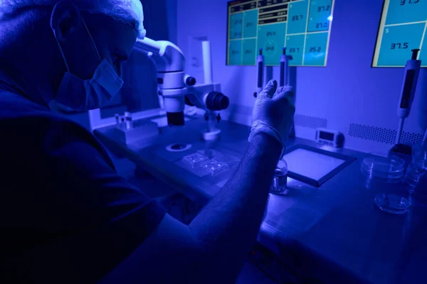 浓缩的男性实验室工作人员混合一些液体 准备必要的营养物质以帮助胚胎生长 在实验室用紫外线工作 — 图库照片