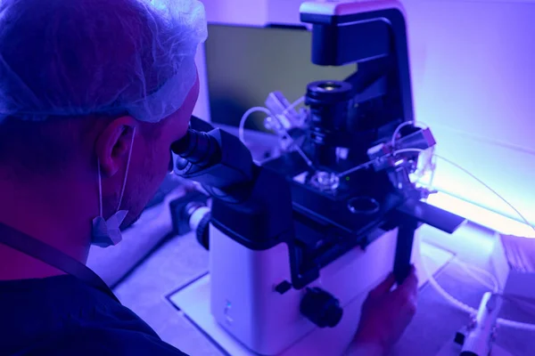 人工实验室技术人员在处理干细胞或胚胎之前用微操作显微镜进行调整 — 图库照片