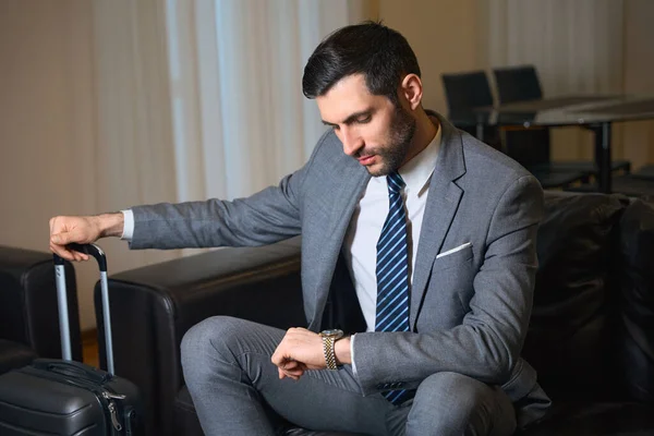 Eleganter Mann Sitzt Auf Einem Ledersofa Und Blickt Auf Seine — Stockfoto