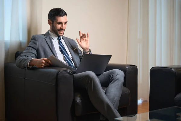 中年のビジネスマンは同僚とラップトップで通信し 男は快適な椅子に位置しています — ストック写真