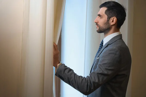 中年宾馆客人站在窗前 男客欣赏风景 — 图库照片