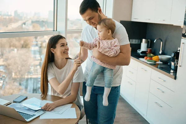 Modern Mother Laptop Works Home Next Her Husband Holding Cute — Stock Photo, Image