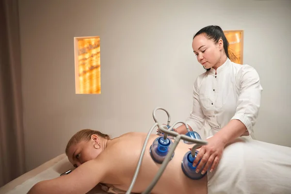 Blond Ligt Massagetafel Met Haar Back Brunette Voert Vacuümtherapie Procedure — Stockfoto