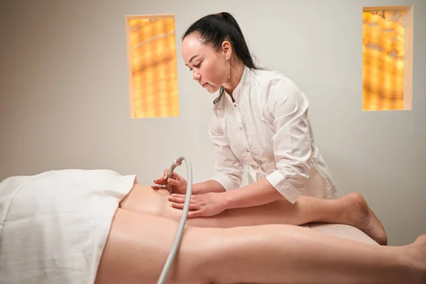 Angenehme Weibliche Masseurin Arbeitet Mit Den Beinen Der Patientin Die — Stockfoto