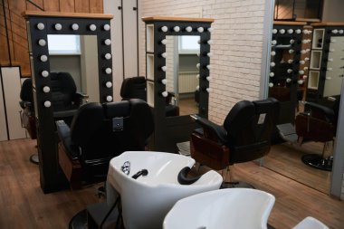Minimalist iç mimarisi olan modern berber salonu, aynalar, lavabolar, mükemmel ışıklandırma.