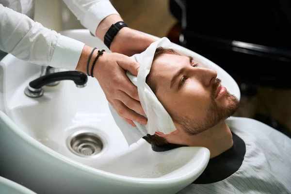 Fryzjer Miejscu Pracy Myje Włosy Młodego Człowieka Klient Znajduje Się — Zdjęcie stockowe