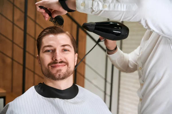 Homem Sorridente Uma Capa Protetora Cadeira Barbeiros Mestre Está Denominando — Fotografia de Stock