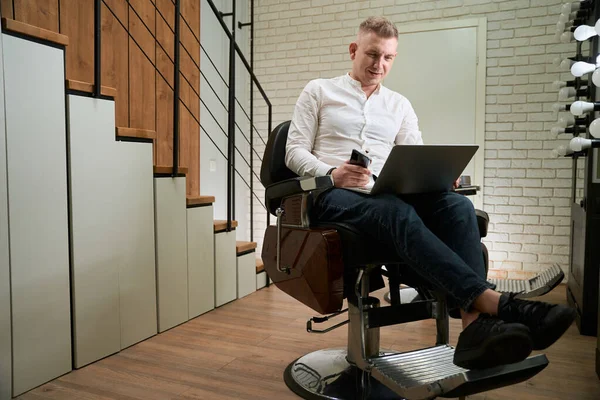 Masculino Uma Camisa Leve Senta Uma Cadeira Barbeiro Confortável Ele — Fotografia de Stock