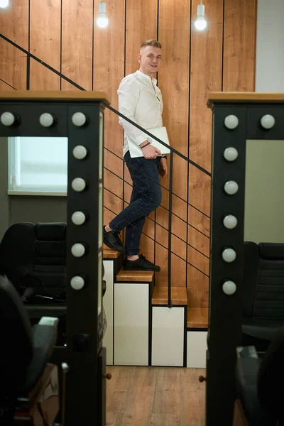 Молодой Человек Спускается Лестнице Парикмахерскую Руках Ноутбук — стоковое фото