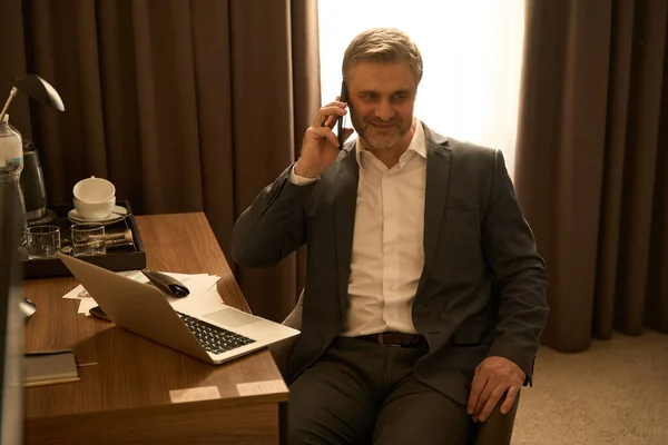 Yerinde Sandalyede Oturan Otel Odasında Telefonla Konuşan Takım Elbiseli Gülümseyen — Stok fotoğraf