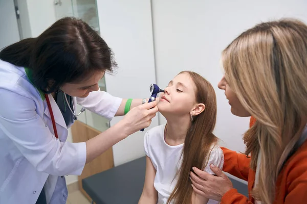 女性の耳 喉の専門家は 小さな女の子の鼻の状態を確認するために光で内視鏡を使用して 私立クリニックでの医学試験 — ストック写真
